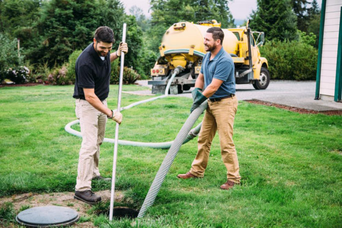 Two men working on a septic system